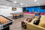 Pool table, shuffle board, wall TV, seating, and a custom art backdrop
